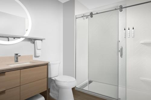 a white bathroom with a shower and a toilet at TownePlace Suites By Marriott Lake City in Lake City