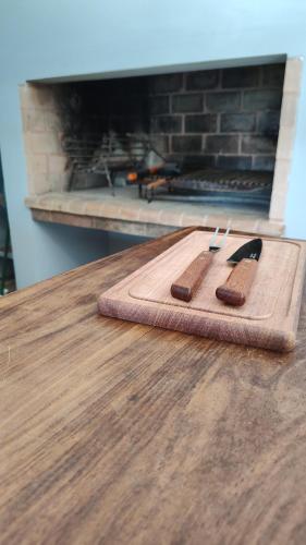 a cutting board with two knives on top of a table at refugioverdelobos in Lobos
