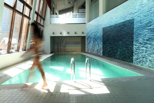 a person walking by a swimming pool at Euphoria Club Hotel in Borovets