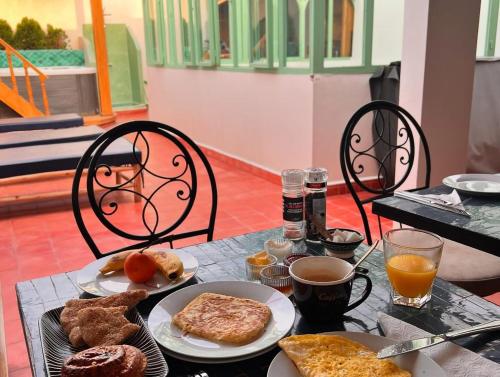 a table topped with plates of breakfast foods and coffee at Riad Madinina in Marrakech