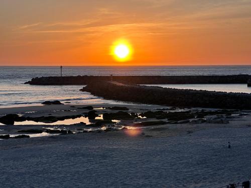 a sunset on the beach with the sun setting at Casa da Praia in Vila Praia de Âncora