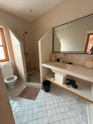 a bathroom with a sink and a toilet and a mirror at Riad Madinina in Marrakech
