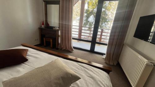 a bedroom with a bed and a large window at Lac Colibita in Colibiţa