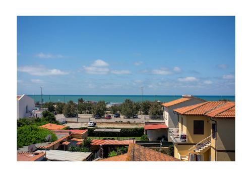 a view of a town with houses and the ocean at MDF Monolocale a Fregene 100 mt dal mare in Fregene