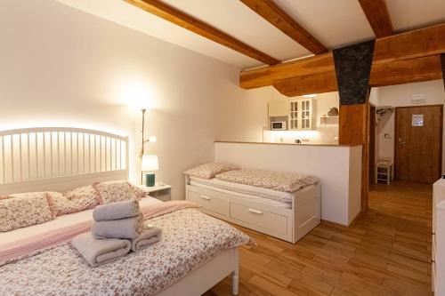 two beds in a bedroom with wooden floors and ceilings at Resort Mlýn Karolínka in Vranov nad Dyjí