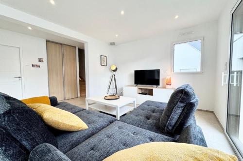 un salon avec un canapé et une télévision dans l'établissement Maison neuve contemporaine - 10min des plages, à Saint-Pierre-Quiberon