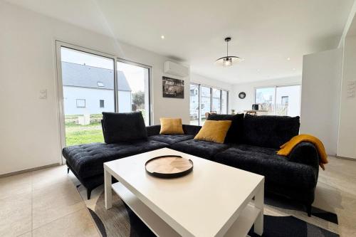 un salon avec un canapé et une table dans l'établissement Maison neuve contemporaine - 10min des plages, à Saint-Pierre-Quiberon
