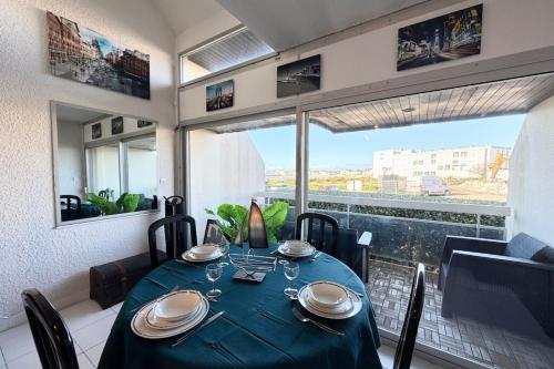 une salle à manger avec une table et une grande fenêtre dans l'établissement Grand triplex vue mer tout confort - Balcon, à Quiberon