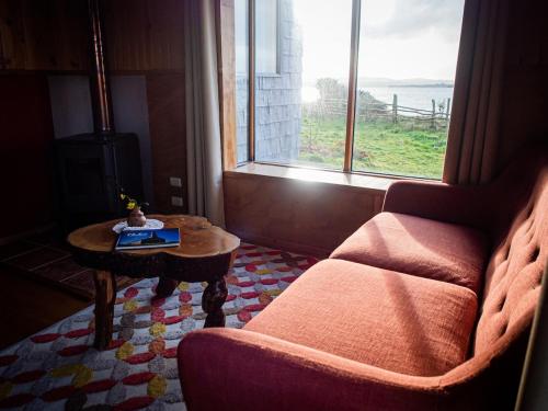a living room with a couch and a table and a window at Beach House Hideaway in Lechagua