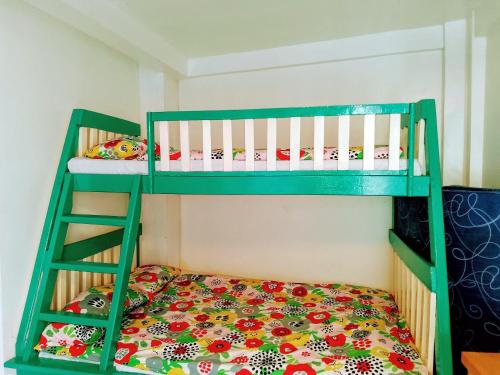 two bunk beds in a room with a bed at Apartment in Holidays Beach Resort in Bolinao