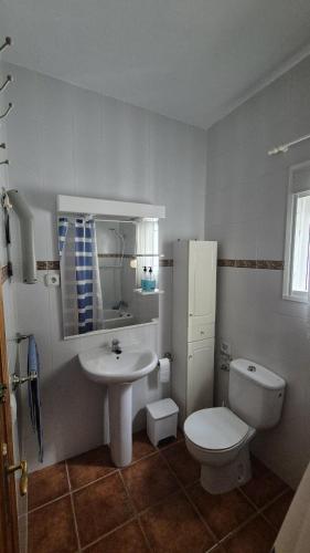 a white bathroom with a toilet and a sink at CASA AGUILAR in Cómpeta