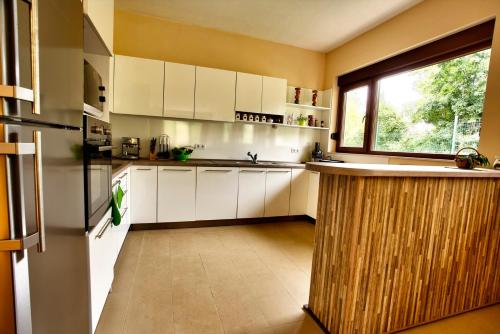 a kitchen with white cabinets and a large window at Holiday Home Marta in Dobrevtsi