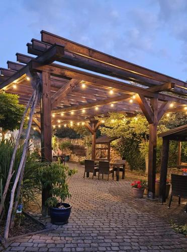 a wooden pergola with lights on a patio at Hotel & Restauracja Timberland in Orzesze