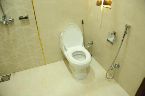 a bathroom with a toilet in a shower stall at Hotel Pak Continental Multan in Multan