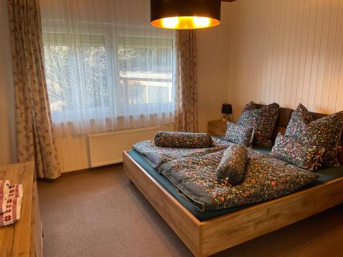 a bedroom with a bed with pillows and a window at Haus Silverfern in Förolach