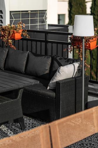 a black couch sitting on a balcony with a lamp at Timber Boutique Hotel in Tbilisi City