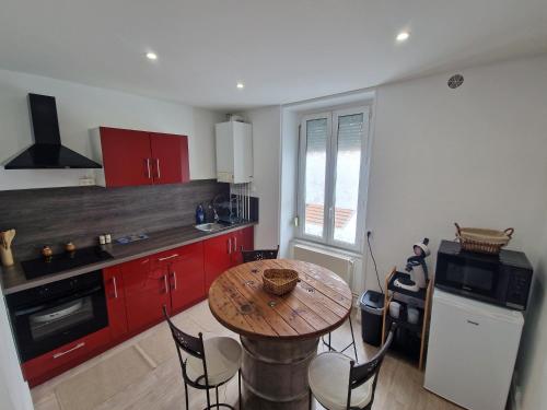 a kitchen with a wooden table and red cabinets at bel appartement,confortable,2chambres in Briey