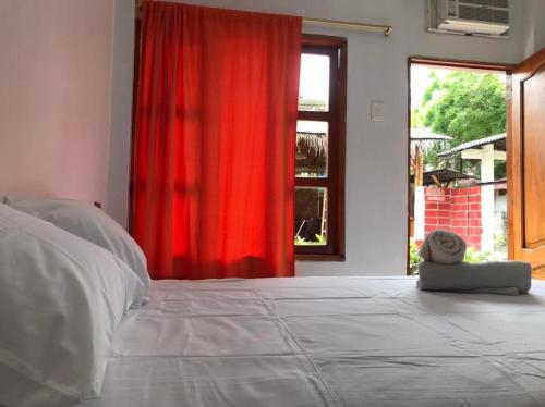 a bedroom with a large bed with a red curtain at Tierra y Mar in Montañita