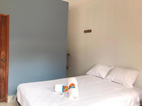 a bedroom with a white bed with towels on it at Tierra y Mar in Montañita