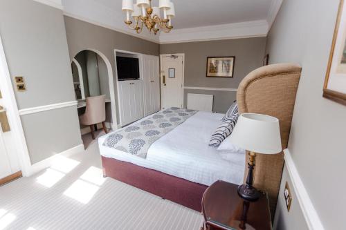 a bedroom with a bed and a table with a lamp at The Snooty Fox in Tetbury