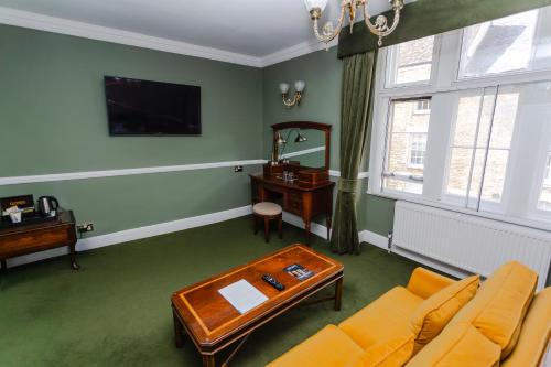 a living room with a couch and a table at The Snooty Fox in Tetbury