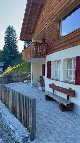 a building with a wooden fence and a bench at Chalet Im Wieselti in Langwies