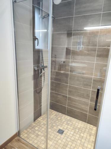 une douche avec une porte vitrée dans une salle de bain dans l'établissement Chambre d'hôtes d'Alex Lebreton, à Cléguer