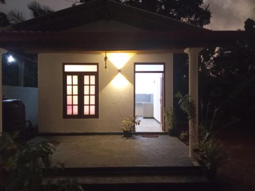 a small house with a door at night at Dream Nest Ahangama in Ahangama