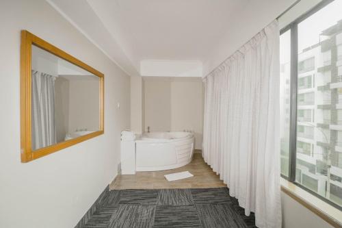 a bathroom with a white tub and a mirror at Hotel Miramar in Lima