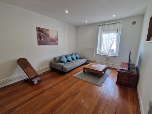 a living room with a couch and a table at bel appartement,confortable,2chambres in Briey