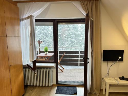 a room with a sliding glass door leading to a balcony at Jacky Apartment in Schonwald im Schwarzwald
