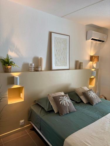a bedroom with a green bed with two pillows at Studio Atoumo Marine 5 in Saint-François