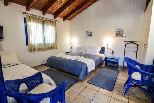 a bedroom with two beds and two chairs in it at Green Village in Xylokastro