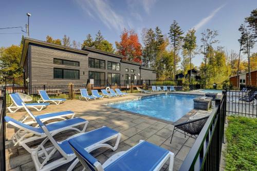 a swimming pool with lounge chairs next to a house at 2CH Relaxation Spa Sauna BBQ Wi-Fi in Pont-Rouge