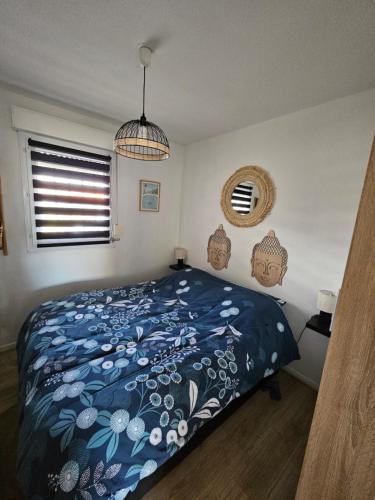 une chambre avec un lit avec une couette bleue dans l'établissement Résidence Les Goelettes Appartement avec terrasse - Clim - Wifi - parking - Piscine - Front de mer, à Saint Cyprien Plage