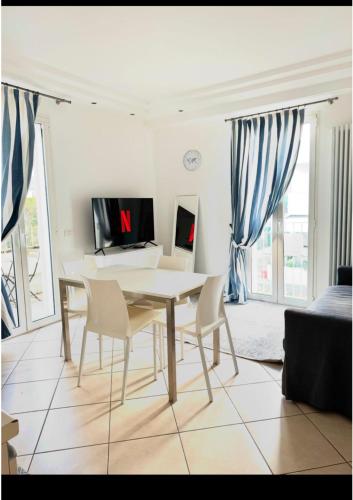 Un comedor blanco con una mesa y sillas. en Appartamento Sul Mare, en Riccione