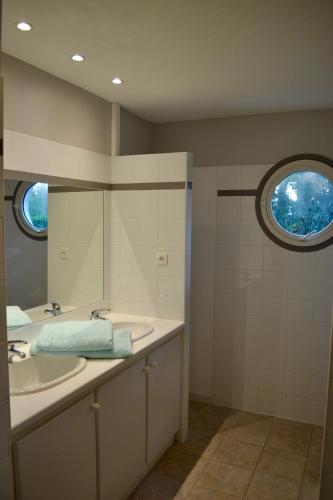 une salle de bain avec deux lavabos et un miroir dans l'établissement Villa avec piscine sur le golf entre lac et Océan, à Biscarrosse