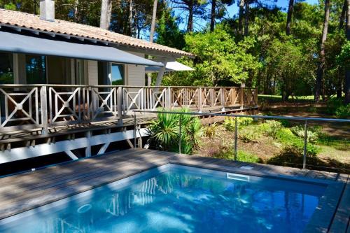 une piscine devant une maison dans l'établissement Villa avec piscine sur le golf entre lac et Océan, à Biscarrosse
