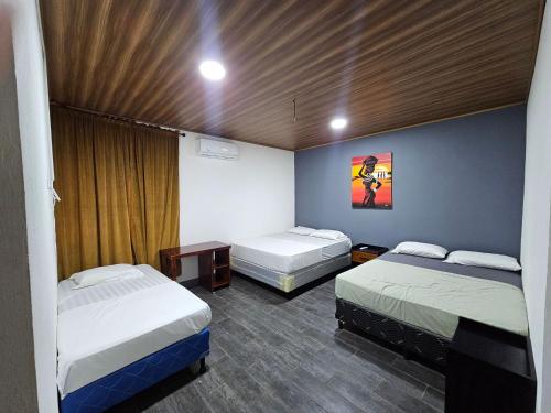 a room with two beds and a table in it at Hostal Mamá Derlys in Moyogalpa