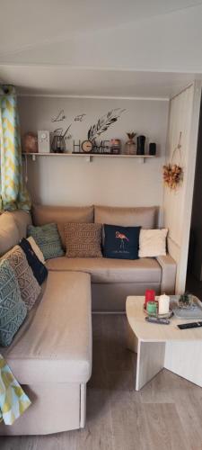un salon avec un canapé et une table dans l'établissement mobilhome Samba 3 chambres, aux Mathes