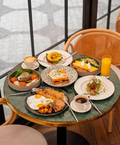 a table with plates of breakfast food on it at Hotel Donald in Odesa