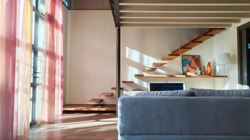 Una sala de estar con un sofá azul y escaleras. en La Casetta del Lago, en Lovere