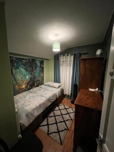 Un dormitorio con una cama y un cuadro en la pared. en room near Luton center, en Luton