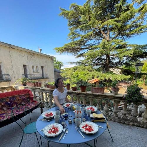 une femme assise à une table avec des assiettes de nourriture dans l'établissement villa marguerite, à Lunas