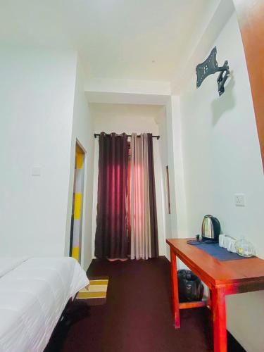 a bedroom with a bed and a red desk at Kithaya Ella in Ella
