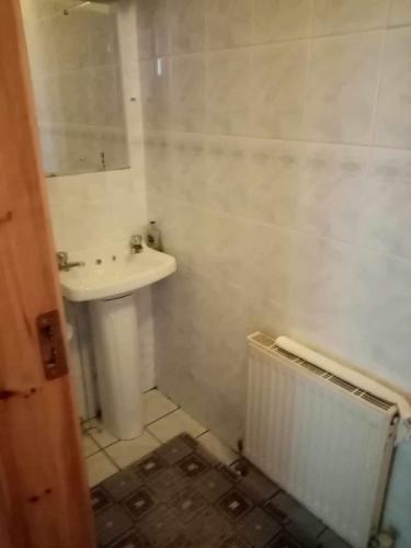 Baño blanco con lavabo y radiador en Atlantic View, en Craggaknock Station