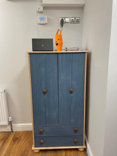 ColindaleにあるComfy Double Room in Colindale With Shared Bathroomの青いキャビネット(ノートパソコン付)