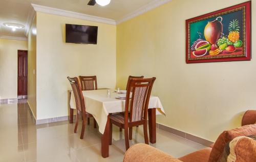 a dining room with a table and chairs and a picture on the wall at BNB Family Vacation Rentals, Corales del Sur, Santo Domingo Este in La Viva