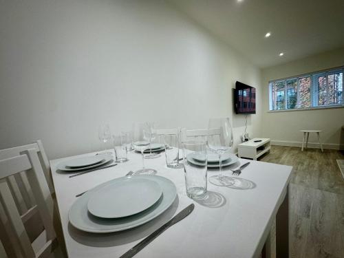 a white table with glasses and plates on it at Seafarers Stays in Southampton