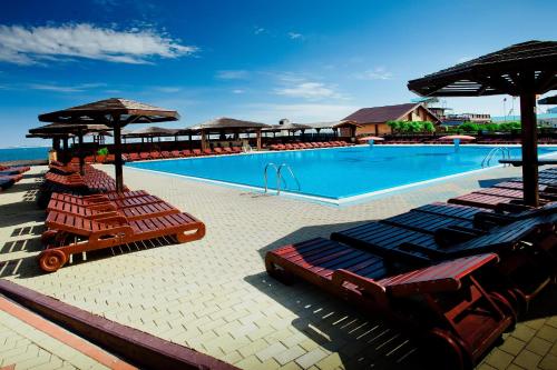 basen z leżakami i parasolami w obiekcie Grand Hotel Valentina w mieście Anapa
